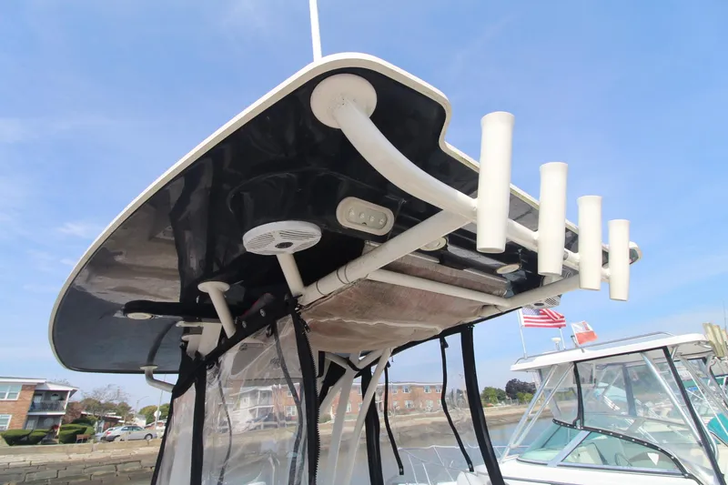 Slide: The Image of 2017 Sailfish 236 CC boat with rod holders and canopy, docked near other boats. - 29