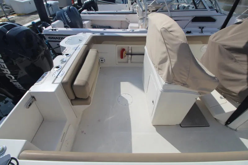 Slide: The Image of 2017 Sailfish 236 CC boat interior with covered seats and spacious deck area. - 3