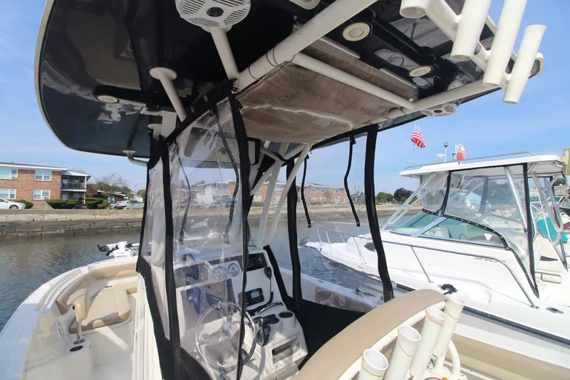 Slide: The Image of 2017 Sailfish 236 CC boat interior with console and seating, docked near other boats. - 30