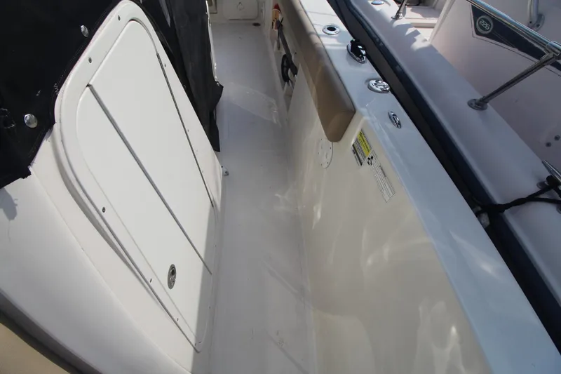Slide: The Image of 2017 Sailfish 236 CC boat interior, featuring white deck and storage compartment. - 31