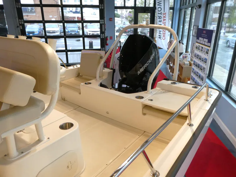Slide: The Image of 2024 Boston Whaler 210 Montauk boat interior with Mercury engine in showroom. - 6