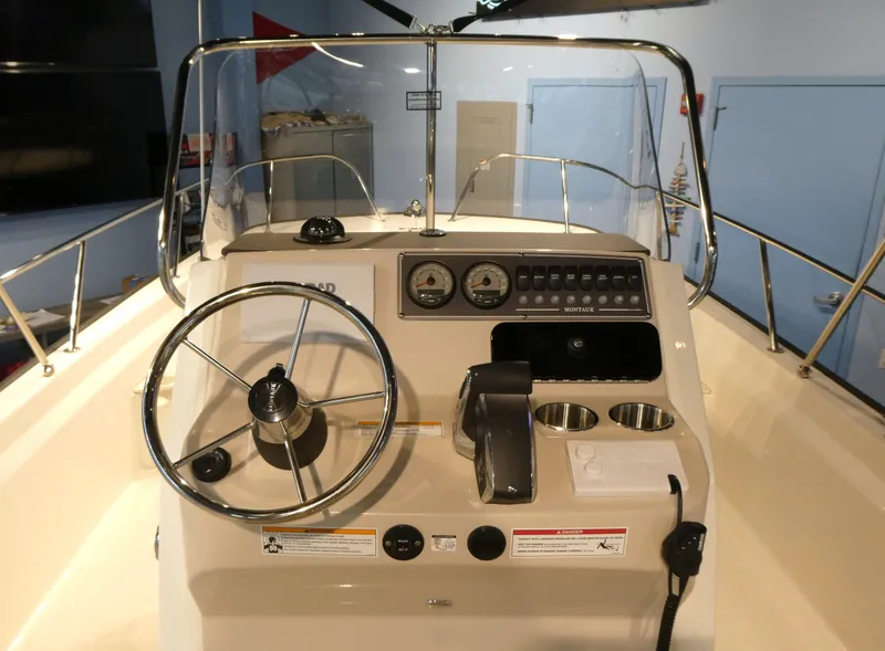 Slide: The Image of 2024 Boston Whaler 210 Montauk boat console with steering wheel and gauges. - 7