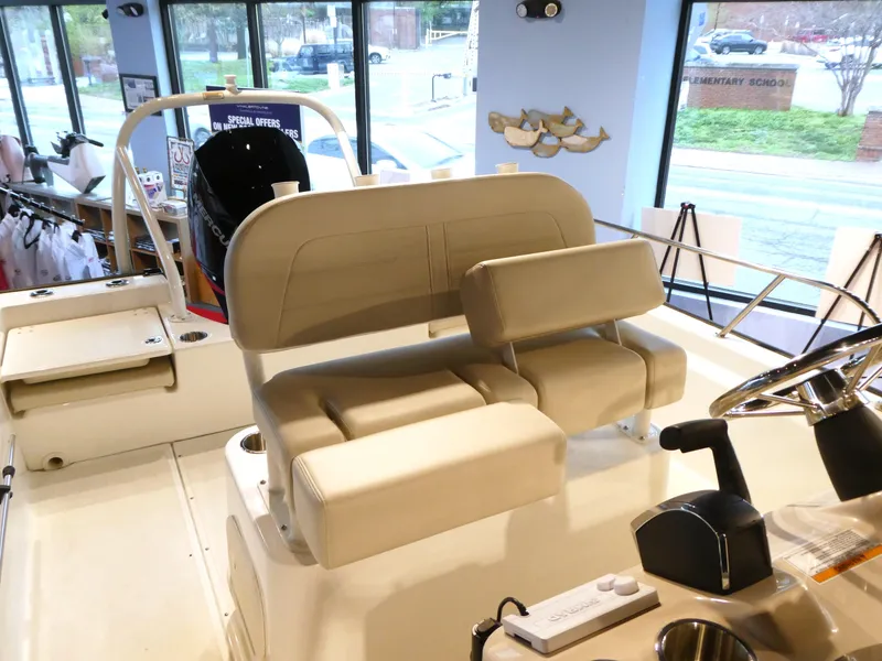Slide: The Image of 2024 Boston Whaler 210 Montauk boat interior with beige seating and control panel. - 8