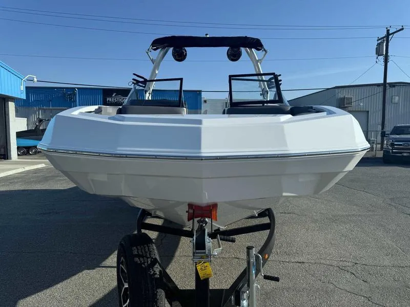 Slide: The Image of 2025 Moomba Max boat on trailer, parked outdoors under clear blue sky. - 12