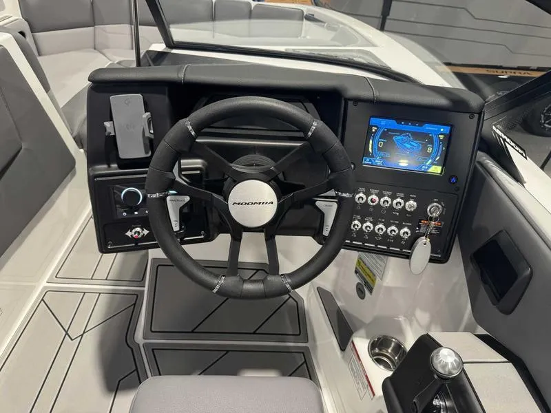 Slide: The Image of 2025 Moomba Max boat dashboard with steering wheel, touchscreen display, and control panel. - 5