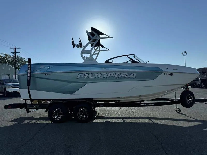 Slide: The Image of 2025 Moomba Max boat on trailer, side view, in a parking lot. - 7