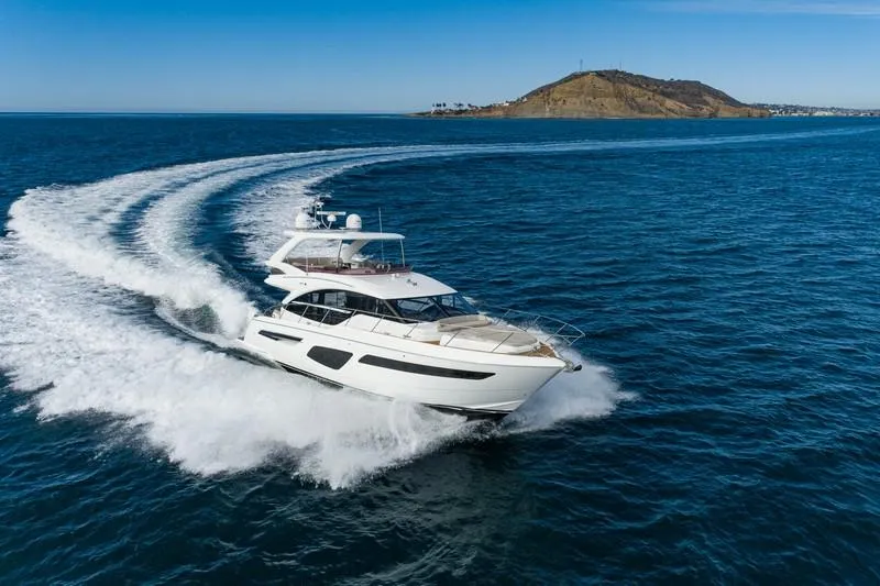 Slide: The Image of 2022 Princess F55 yacht cruising on open sea near a coastal hill. - 13