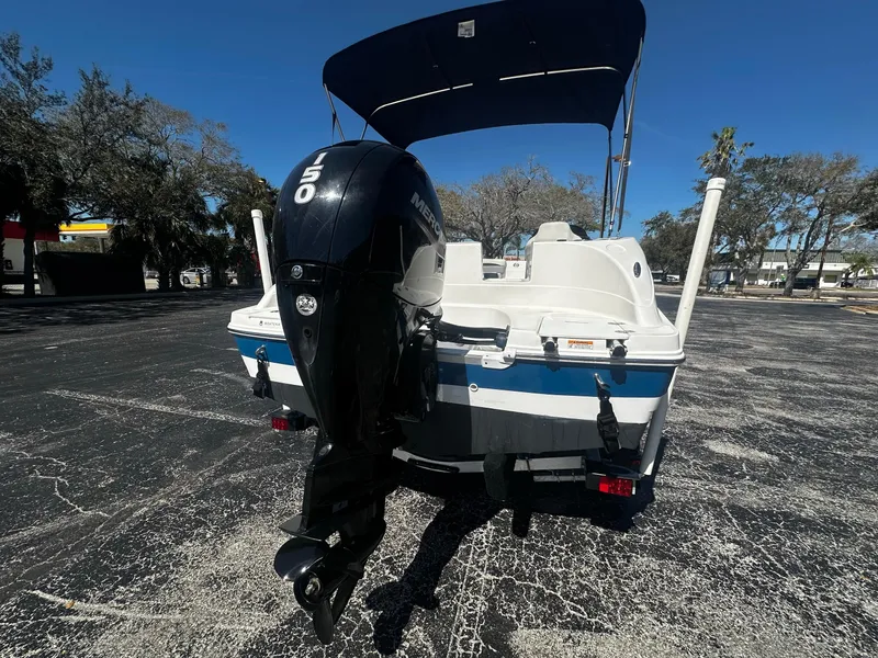 Slide: The Image of 2022 Hurricane SS 192RL boat with outboard motor, parked on asphalt under clear blue sky. - 3