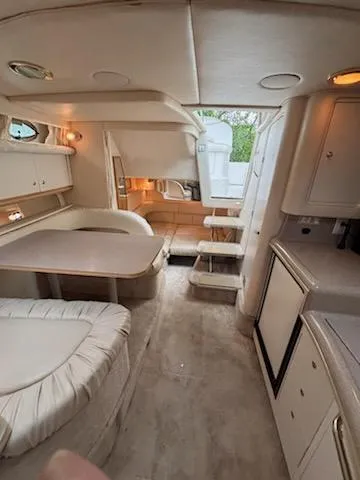Slide: The Image of Interior of 2000 Sea Ray 340 Sundancer yacht, featuring dining area and kitchenette. - 10