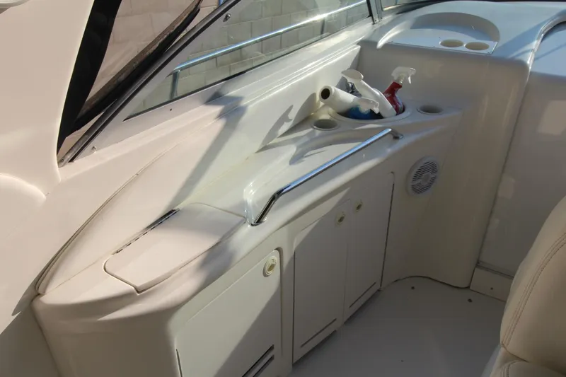 Slide: The Image of 2000 Sea Ray 340 Sundancer cockpit with storage cabinets and cleaning supplies. - 17