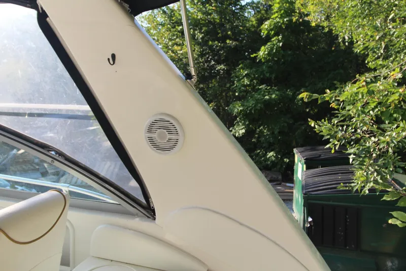 Slide: The Image of 2000 Sea Ray 340 Sundancer boat interior with speaker, surrounded by lush greenery. - 21