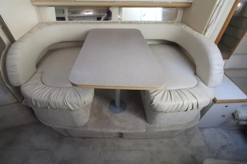 Slide: The Image of 2000 Sea Ray 340 Sundancer interior with cushioned seating and dining table. - 23