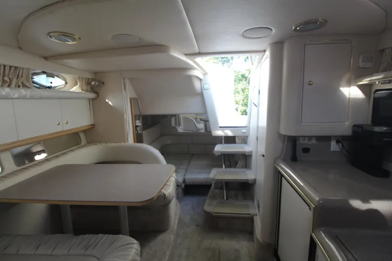 Slide: The Image of Interior of 2000 Sea Ray 340 Sundancer yacht, featuring dining area and kitchenette. - 25
