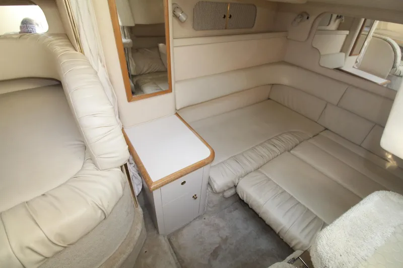 Slide: The Image of Interior of 2000 Sea Ray 340 Sundancer, featuring beige leather seating and compact cabin layout. - 30