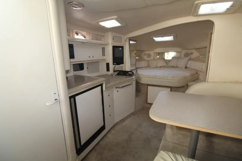 Slide: The Image of Interior of 2000 Sea Ray 340 Sundancer yacht, featuring kitchenette and cozy sleeping area. - 32