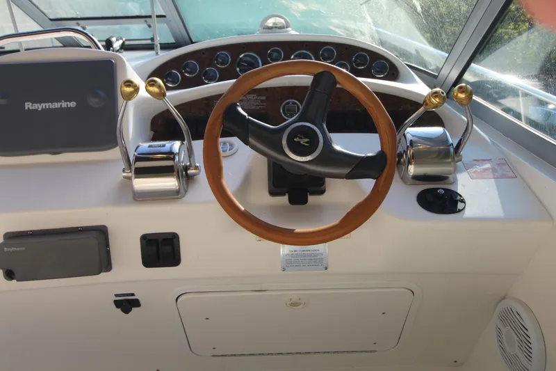 Slide: The Image of Control panel of a 2000 Sea Ray 340 Sundancer boat with steering wheel and navigation equipment. - 4