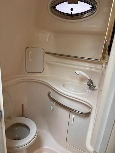 Slide: The Image of 2000 Sea Ray 340 Sundancer bathroom with sink, toilet, and porthole window. - 47