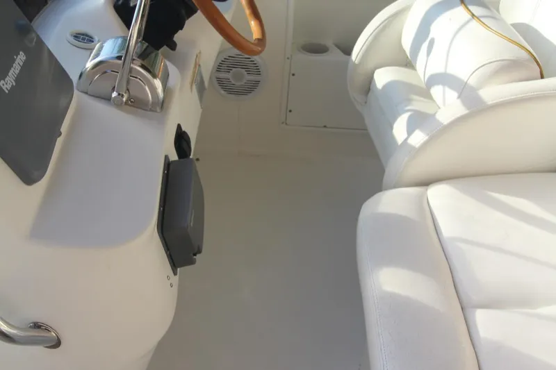 Slide: The Image of Interior view of 2000 Sea Ray 340 Sundancer boat with white seating and steering wheel. - 49