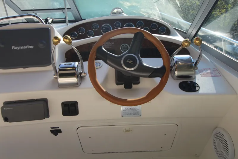 Slide: The Image of Steering wheel and controls of a 2000 Sea Ray 340 Sundancer boat. - 5