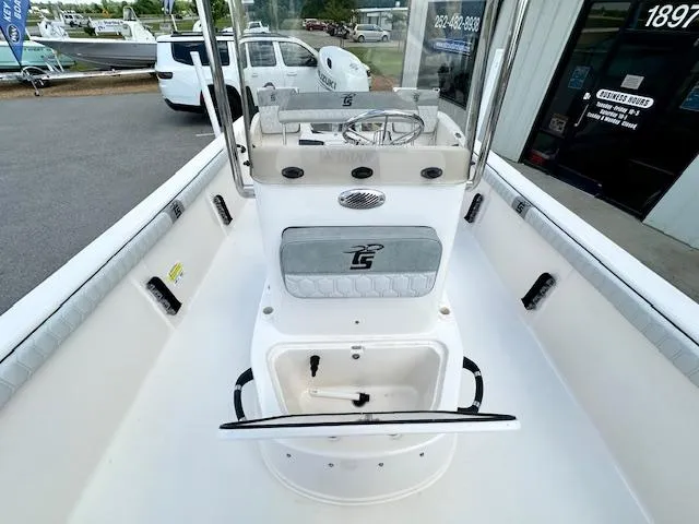 Slide: The Image of 2025 Carolina Skiff 19 LS boat interior with console and seating, parked outdoors. - 10
