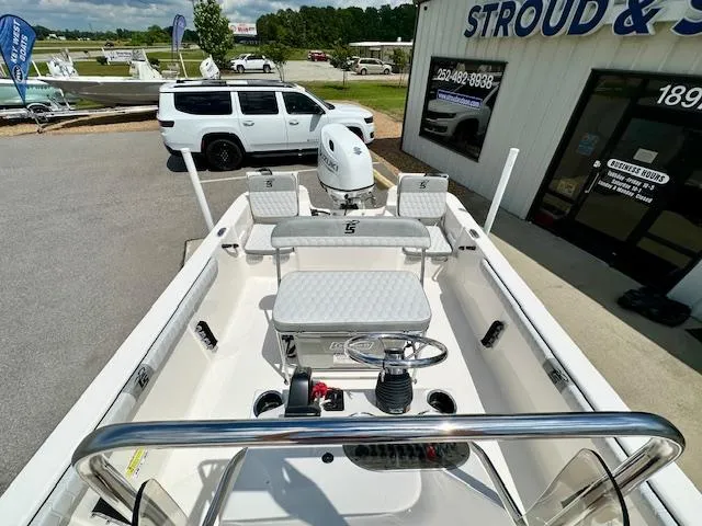 Slide: The Image of 2025 Carolina Skiff 19 LS boat displayed outside dealership with white SUV nearby. - 14