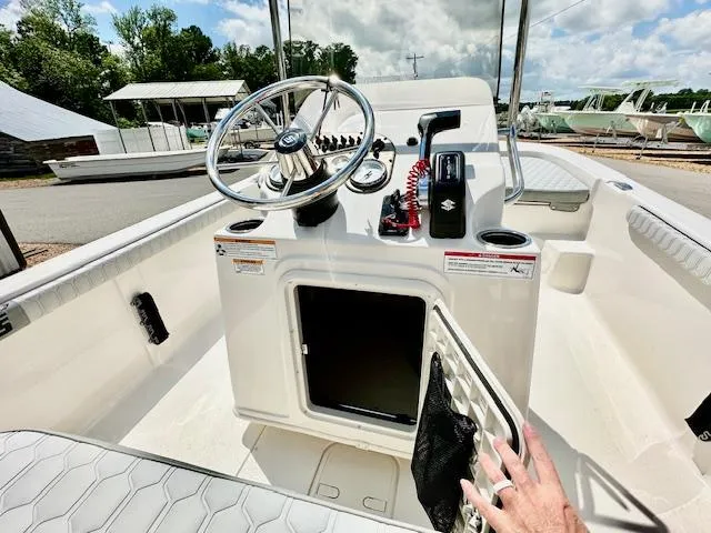 Slide: The Image of 2025 Carolina Skiff 19 LS boat interior with steering console and open storage compartment. - 7