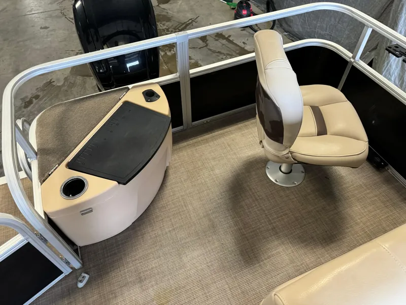 Slide: The Image of 2019 Sun Tracker Fishin' Barge 20 DLX interior with beige seating and control panel. - 14