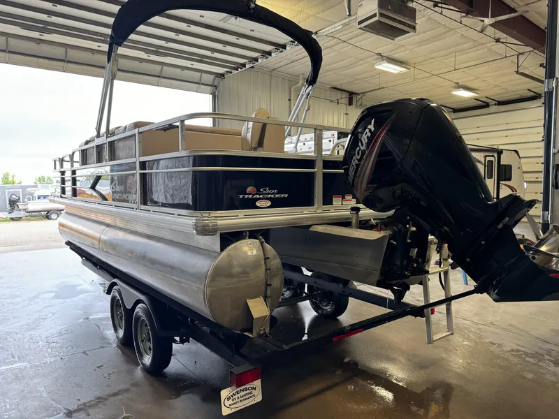 Slide: The Image of 2019 Sun Tracker Fishin' Barge 20 DLX pontoon boat in a garage setting. - 4