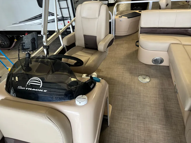 Slide: The Image of 2019 Sun Tracker Fishin' Barge 20 DLX interior with beige seating and steering console. - 9