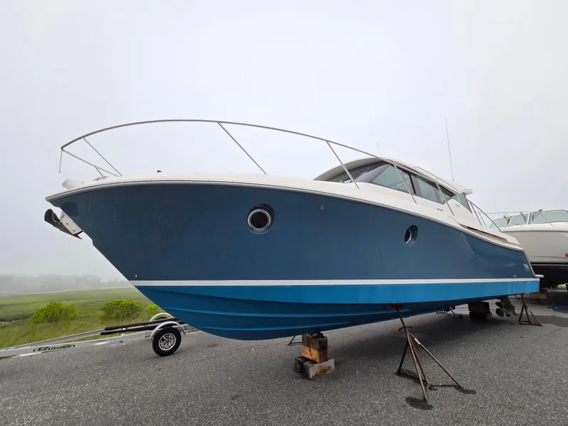 Slide: The Image of 2018 Tiara Yachts 39 boat on stands, blue hull, overcast sky. - 1