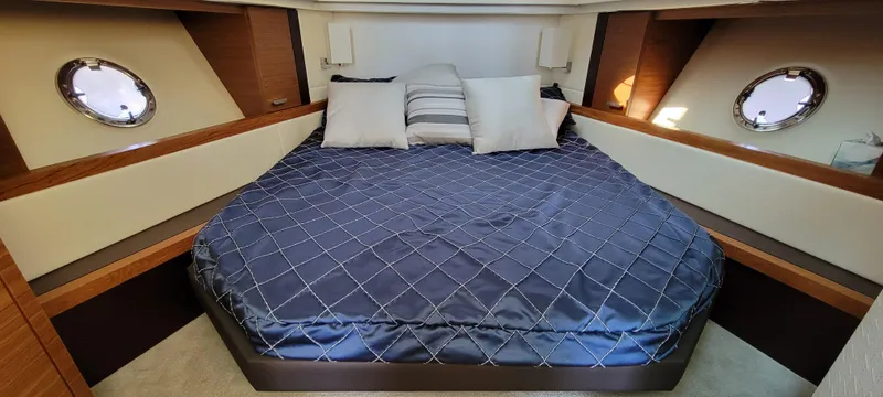 Slide: The Image of Luxurious 2018 Tiara Yachts 39 cabin with elegant bedding and porthole windows. - 17