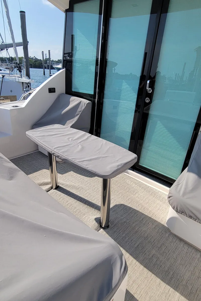 Slide: The Image of 2018 Tiara Yachts 39 cockpit with covered seating and table, docked at marina. - 8