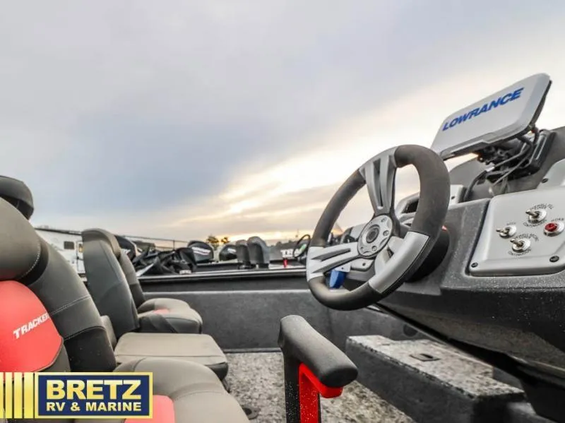 Slide: The Image of 2025 Pro Team 175 TXW boat interior with steering wheel and Lowrance equipment. - 11