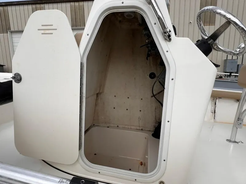 Slide: The Image of 2016 Key West 210 Bay Reef boat console storage compartment with open door. - 12