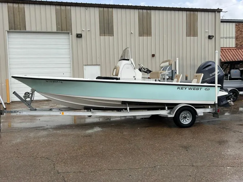 Slide: The Image of 2016 Key West 210 Bay Reef boat on trailer, parked outside industrial building. - 5