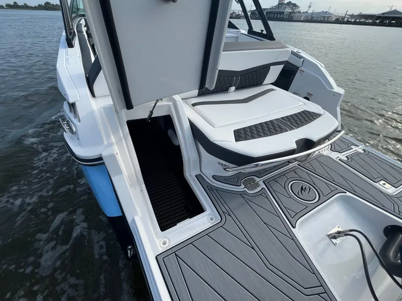 Slide: The Image of 2025 Monterey 255 Super Sport boat deck with seating and storage, on calm water. - 10