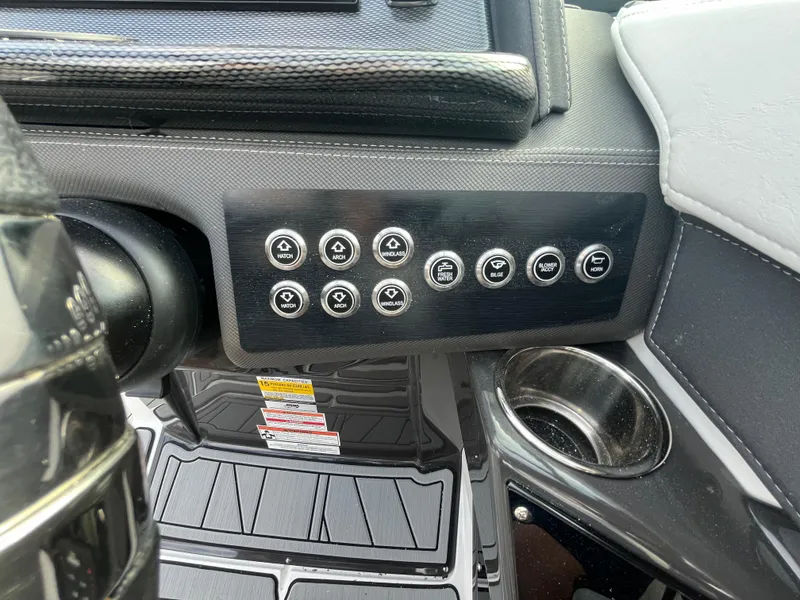 Slide: The Image of Control panel of 2025 Monterey 255 Super Sport boat with multiple buttons and cup holder. - 30