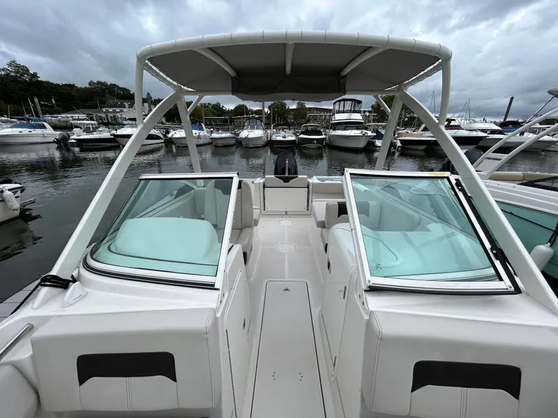 Slide: The Image of 2024 Sailfish 226 DC boat docked at marina, featuring open deck and seating. - 12