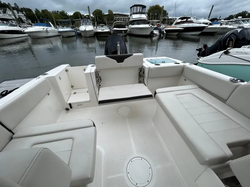 Slide: The Image of 2024 Sailfish 226 DC boat interior with spacious seating at marina. - 13