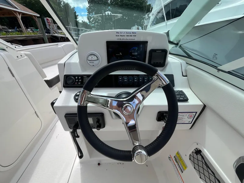 Slide: The Image of 2024 Sailfish 226 DC boat dashboard with steering wheel and control panel. - 19