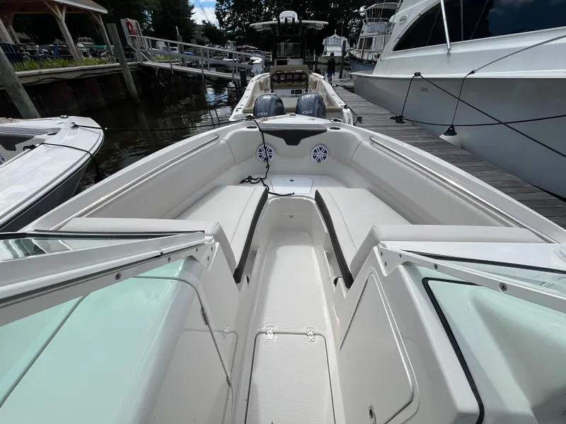 Slide: The Image of 2024 Sailfish 226 DC boat interior with spacious seating and modern design at a marina. - 20