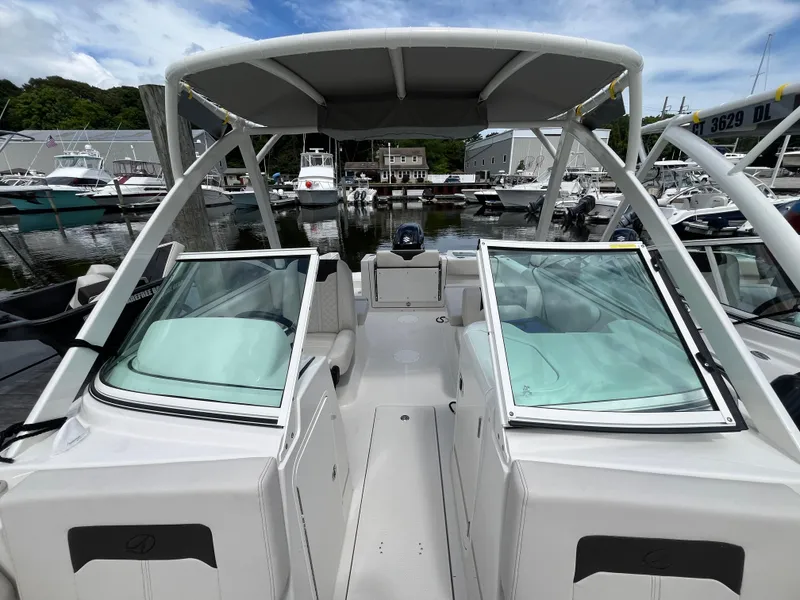 Slide: The Image of 2024 Sailfish 226 DC boat interior with open windshield, docked at marina. - 21