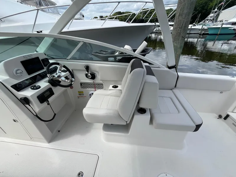 Slide: The Image of 2024 Sailfish 226 DC boat interior with white seating and steering console. - 23