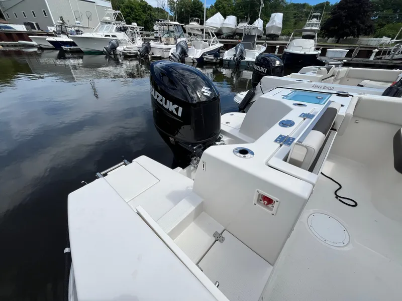 Slide: The Image of 2024 Sailfish 226 DC boat with Suzuki outboard motor docked at marina. - 24