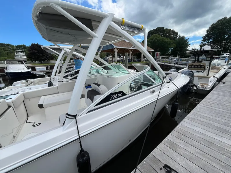 Slide: The Image of 2024 Sailfish 226 DC boat docked at marina under cloudy sky. - 3