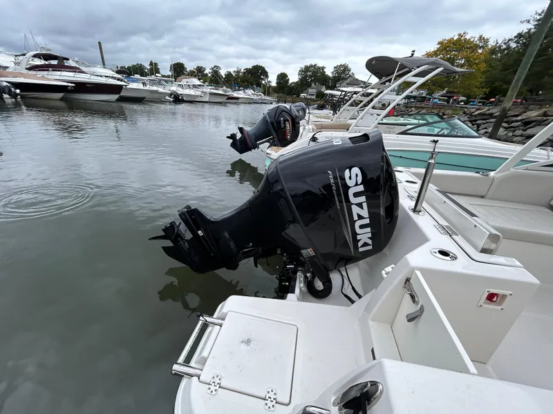 Slide: The Image of 2024 Sailfish 226 DC boat with Suzuki outboard motor docked in marina. - 6