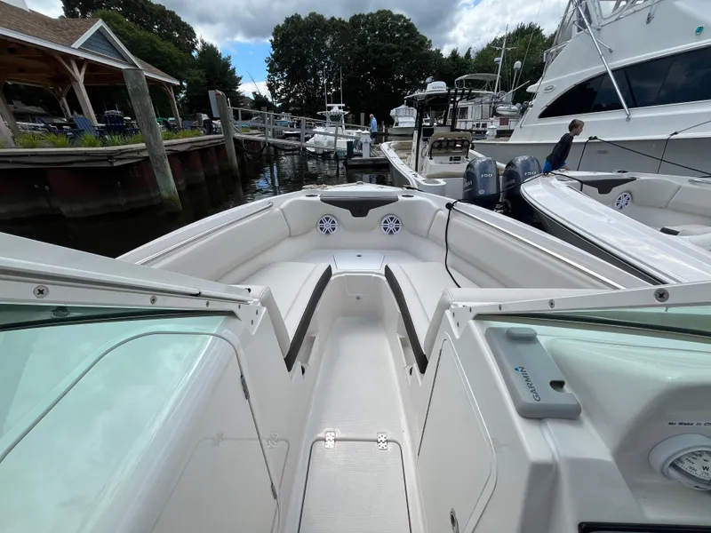 Slide: The Image of 2024 Sailfish 226 DC boat docked at marina, showcasing spacious seating and modern design. - 10