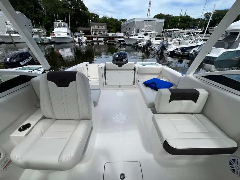 Slide: The Image of 2024 Sailfish 226 DC boat interior with white seating, docked at a marina. - 12