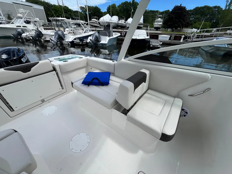 Slide: The Image of 2024 Sailfish 226 DC boat interior with seating at marina. - 13
