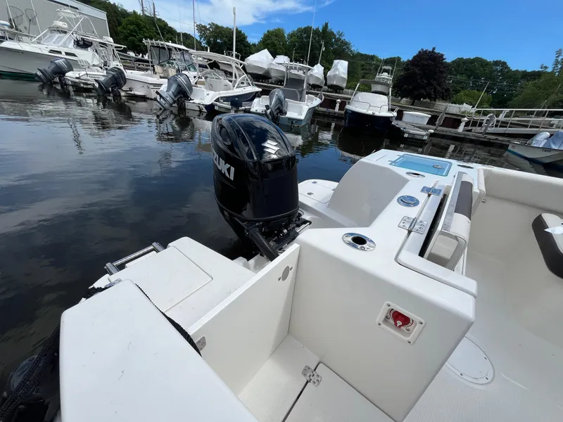 Slide: The Image of 2024 Sailfish 226 DC boat docked with Suzuki outboard motor. - 15